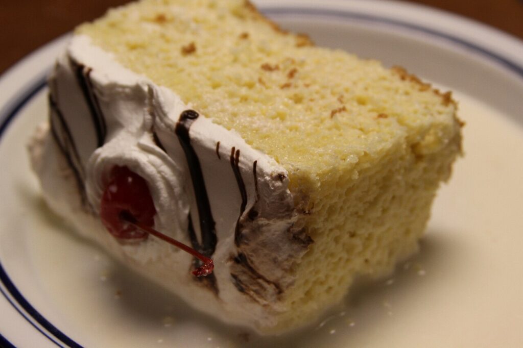 Rebanada de pastel de tres leches con cobertura de crema batida
