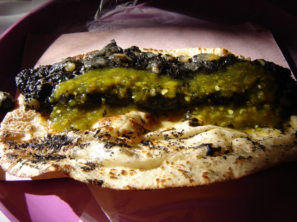 Quesadilla de huitlacoche con queso Oaxaca y epazote en comal