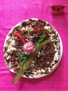 Tlayuda oaxaqueña con frijoles, quesillo, carne, lechuga y aguacate