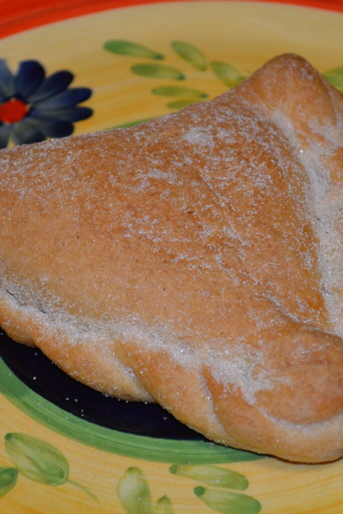 Empanada dulce de horno espolvoreada con azúcar