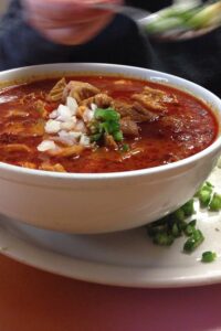 Menudo norteño en tazón con cebolla, orégano y limón
